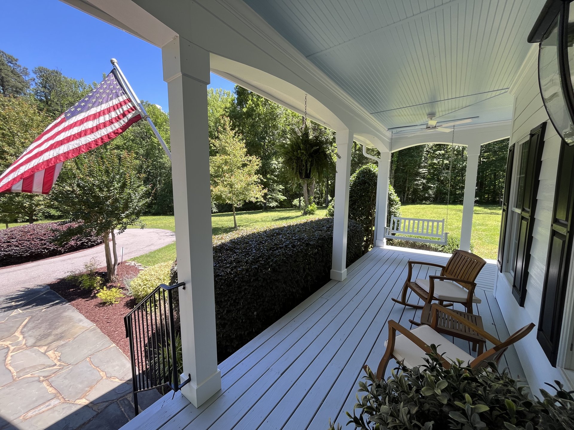 Wraparound front porch with rocking chairs and porch swing